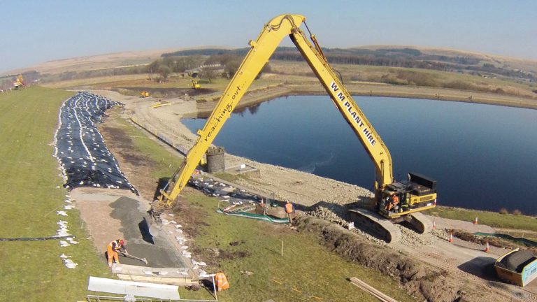 A long reach excavator being used to place the part-face filter blanket. Use of this plant item vastly decreased the duration required for this operation - Courtesy of MMB