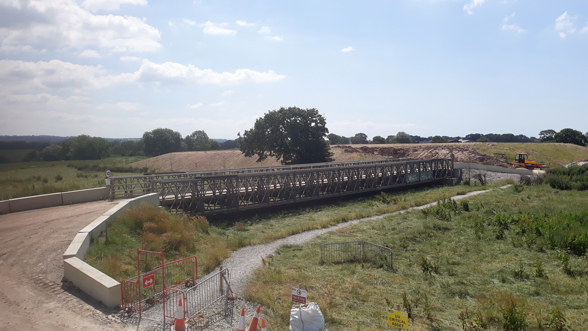 Bailey Bridge crossing and protecting critical assets, (water aqueducts) and 84,000m3 clay mound in background - Courtesy of United Utilities