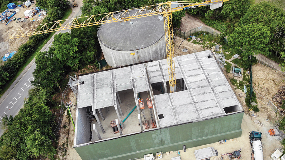 Tank under construction, showing precast concrete slabs being maneuvered into place by a crane - Courtesy of Stonbury