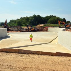 New spillway construction with embankment breach in progress in the background - Courtesy of Canal & River Trust